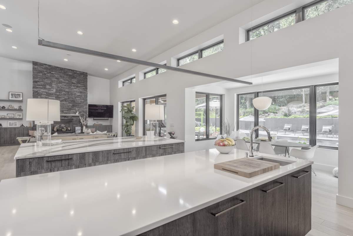 A large kitchen with white counters and marble countertops.