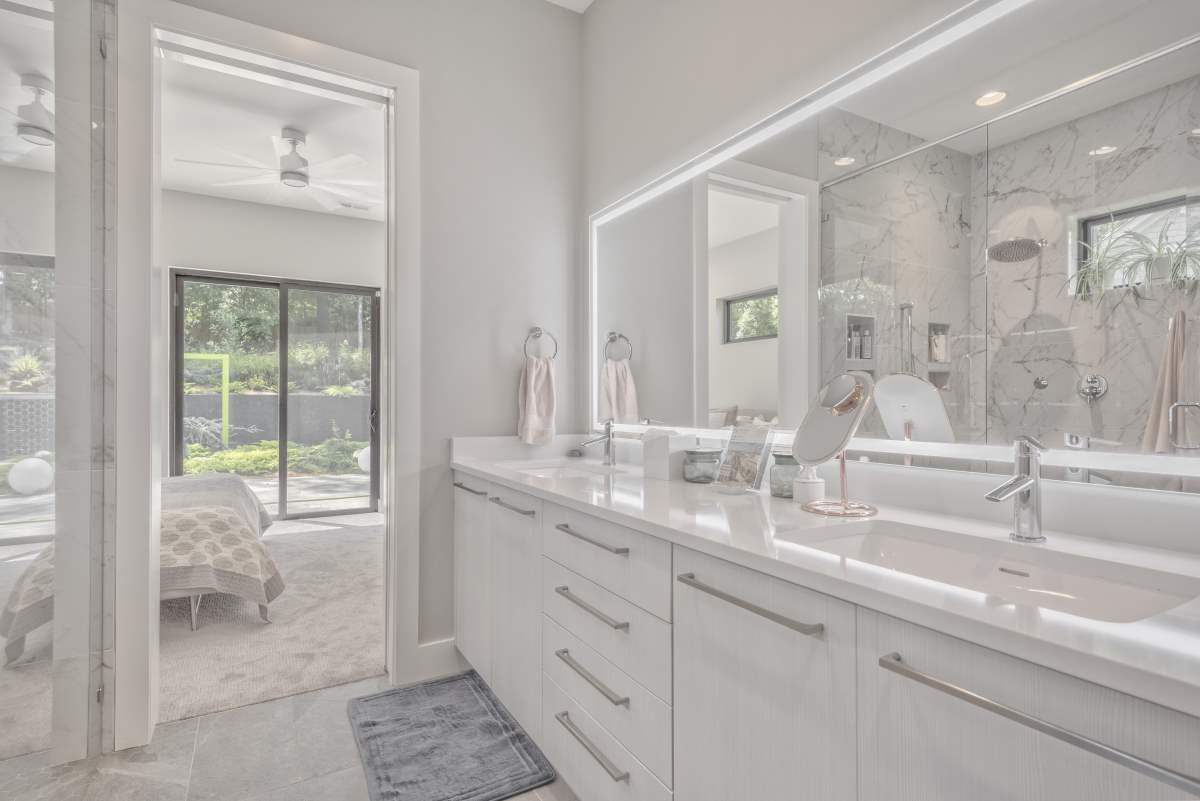 A bathroom with two sinks and a large mirror.