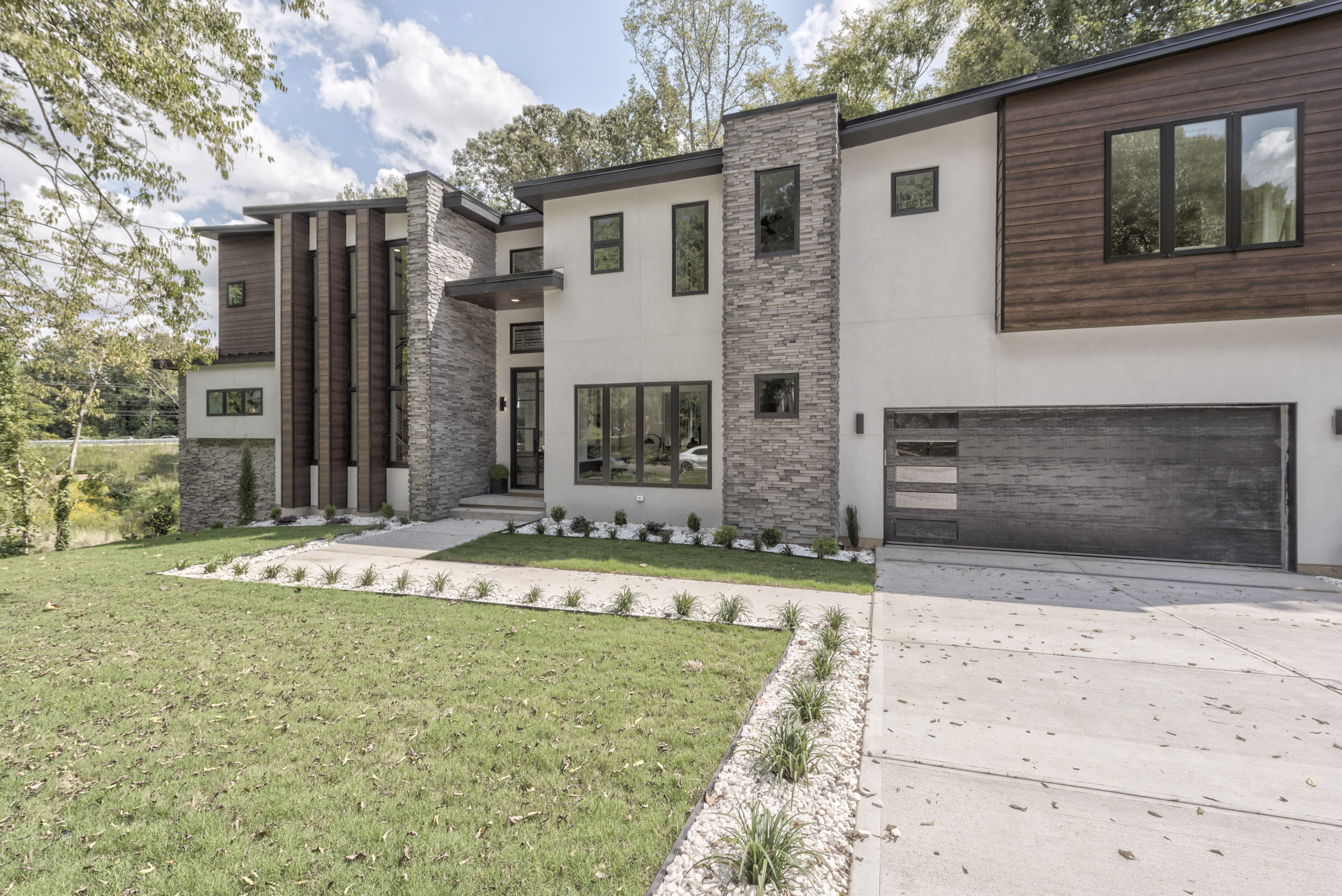 A large modern home with a grassy lawn.