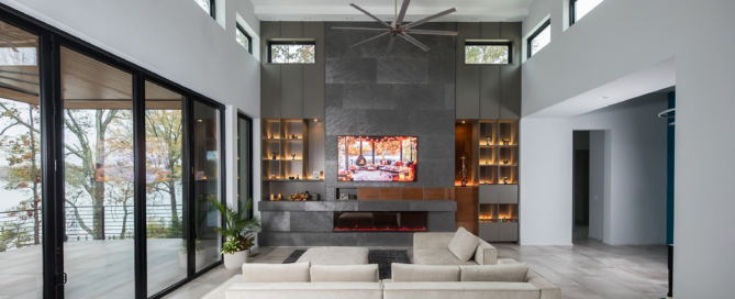 Modern gray slate living room with electric fire place, natural light, and folding glass doors.