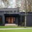 Artistic Contractors black modern home with rose gold front doors