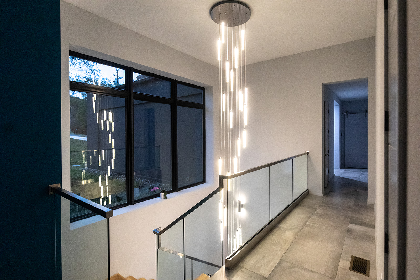 Modern staircase with center waterfall chandelier lighting