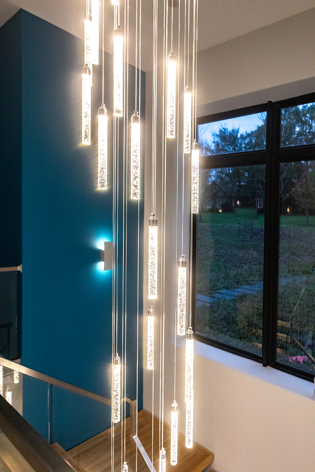 Modern staircase with center waterfall chandelier lighting